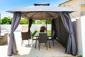 einen Tisch und Stühle unter einem großen Sonnenschirm auf einer Terrasse in der Unterkunft Villa Suzy in Medulin