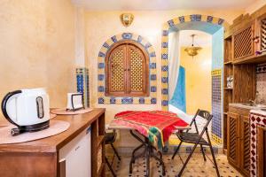 une cuisine avec une table et un four micro-ondes sur un comptoir dans l'établissement Dar Sandra Moroccan Tiny House, à Tanger