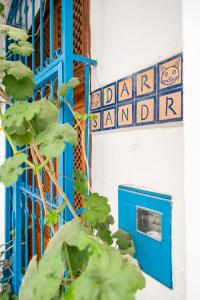 une porte bleue et un panneau sur un bâtiment dans l'établissement Dar Sandra Moroccan Tiny House, à Tanger