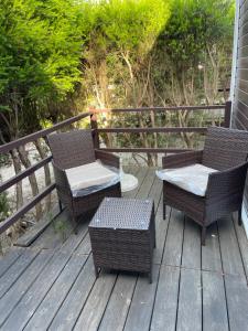 two chairs and a table on a deck at Quinta Dos Amarelos no Meco in Aldeia do Meco