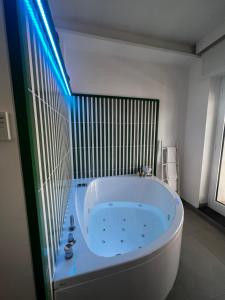 La salle de bains est pourvue d'une grande baignoire blanche et de lumières bleues. dans l'établissement Al Campanile, à Sant'Agnello