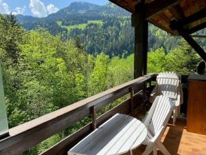 two white chairs on a porch with a view of trees at Appartement Le Grand-Bornand, 4 pièces, 8 personnes - FR-1-458-151 in Le Grand-Bornand