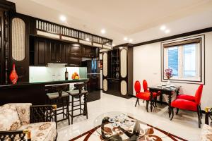 a kitchen and living room with red chairs and a table at Wild Lotus Hotel Apartment 2 in Hanoi