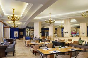 un ristorante con tavoli, sedie e lampadari di The Ritz-Carlton Jakarta, Mega Kuningan a Giacarta