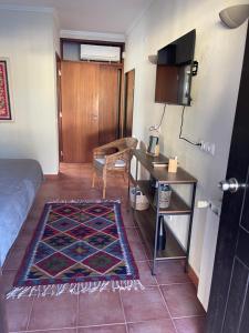 a room with a bed and a table and a desk at Quinta Dos Amarelos no Meco in Aldeia do Meco