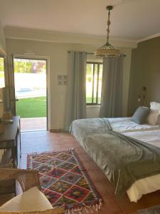 a bedroom with a bed and a desk and a window at Quinta Dos Amarelos no Meco in Aldeia do Meco