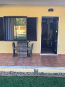 a patio with a table and chairs in front of a house at Quinta Dos Amarelos no Meco in Aldeia do Meco