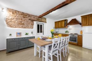 eine Küche mit einem Holztisch und weißen Geräten in der Unterkunft Casa Anastasia in Novigrad Istria