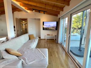 ラガナスにあるOsservatorio Houseの白いソファとテレビのあるリビングルーム
