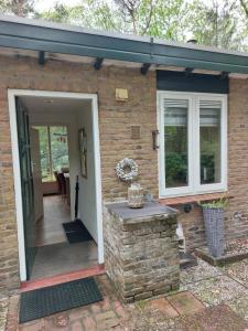 uma casa de tijolos com uma porta e uma parede de pedra em Ons Stekkie em Holten