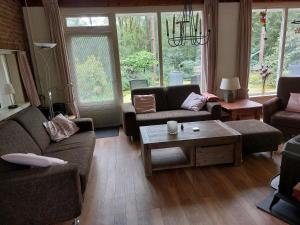 uma sala de estar com sofás e uma mesa de centro em Ons Stekkie em Holten