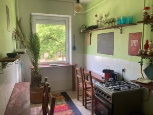 a kitchen with a stove and a table and a window at Pálmaház in Budapest