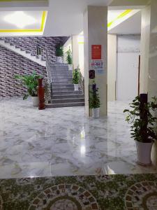 a lobby with stairs and potted plants in a building at Khách sạn Thanh Bình Bến Lức in Bến Lức
