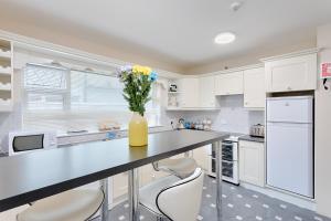 a kitchen with white cabinets and a vase of flowers on a counter at Silver Sea in Galway