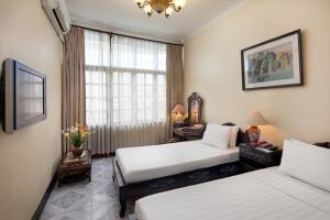 pokój hotelowy z dwoma łóżkami i oknem w obiekcie Lucky Central Hotel & Travel w mieście Hanoi +11 zdjęć