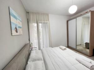 a bedroom with a bed and a large mirror at Olives Terrace B2A5 Apartment in Dhërmi +9 photos