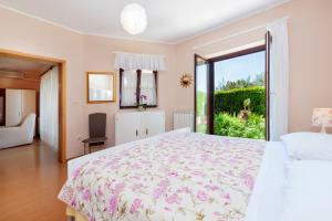1 dormitorio con cama grande y ventana grande en Apartments Villa Brigita en Rovinj