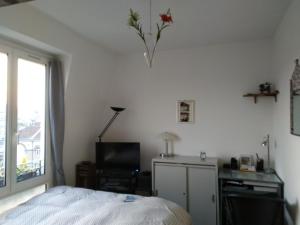 1 dormitorio con cama, escritorio y ventana en APPARTEMENT DE CHARME, en París