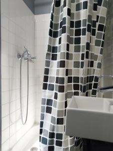 a bathroom with a black and white shower curtain and a sink at APPARTEMENT DE CHARME in Paris