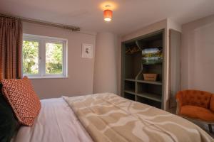 a bedroom with a bed and a window and a chair at Contemporary Home with Parking by LetMeStay in Kendal