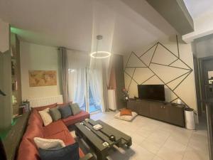 a living room with a couch and a tv at Seaside apartment in Athens