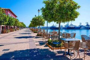 una fila de mesas y sillas junto al agua en Seaside apartment, en Atenas