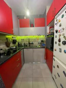 a small kitchen with red cabinets and a refrigerator at Seaside apartment in Athens