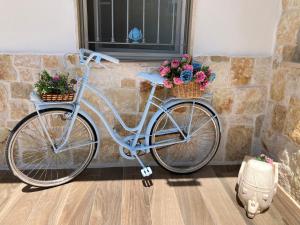 Una bicicleta azul con dos cestas y flores. en Il Casale Di Kevin, en Monopoli