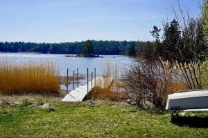 a dock in the grass next to a body of water at Spillersboda stuga med båtar in Spillersboda