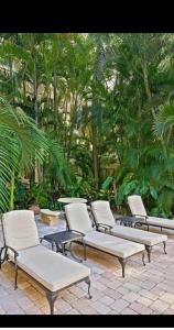 a row of chairs and tables on a patio at Tropical Elegant Palm Beach 2 Bedroom 2 Bathroom Suite Valet Parking Included in Palm Beach