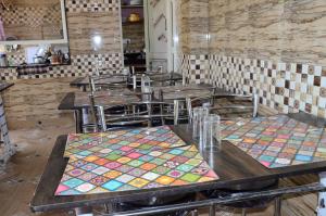 a restaurant with tables and chairs with colorful mats on them at Bhandari Homestay and Restaurant in Mussoorie