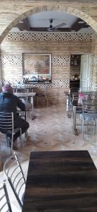 a person sitting at a table in a restaurant at Bhandari Homestay and Restaurant in Mussoorie
