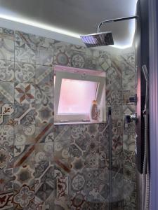 a bathroom with a shower with a screen on the wall at Loft Largo Gloria in Messina