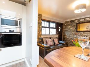 a living room with a couch and a table with a wine glass at Bwthyn Clyd in Dyffryn