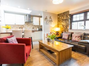 a living room with a couch and a table at Bwthyn Clyd in Dyffryn