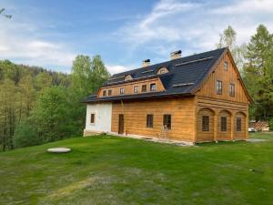 a large wooden house on a field with a frisbee at Na jelení stezce in Chřibská