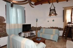 a living room with a couch and a tv at Splendida villa in riva al mare in Orosei