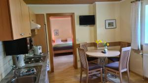 a kitchen with a table and a room with a bed at Dependance II in Schladming