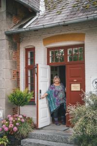 una mujer parada en la puerta de una casa en Edelsminde Bed & Breakfast en Haslev