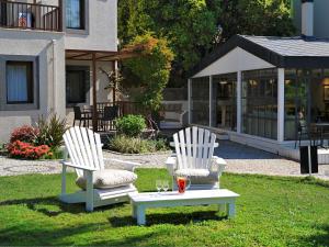 twee witte stoelen en een tafel in het gras bij Dorman Suites in Bitez