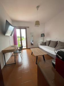 een woonkamer met een bank en een tafel bij Kapodistriou Apartments in Aegina Town