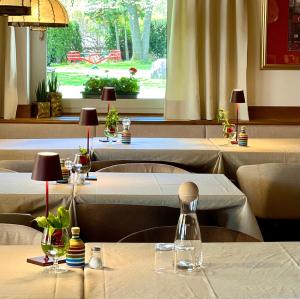 un restaurante con varias mesas con manteles blancos en Ameiserhof Guesthouse, en Collalbo