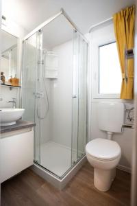 a bathroom with a shower and a toilet and a sink at Lavanda Mobile Home at Terra Park Spiritos camp in Kolan