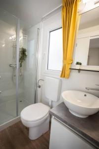 a bathroom with a toilet and a sink and a shower at Lavanda Mobile Home at Terra Park Spiritos camp in Kolan