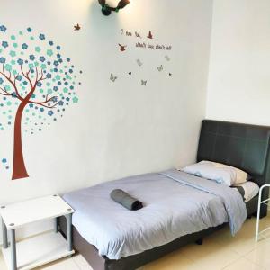 a bedroom with a tree and butterflies on the wall at Comfy Home Near to SPICE and USM in Bayan Lepas