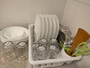 einem weißen Behälter mit Gläsern, Tellern und Scheren in der Unterkunft Comfy Home Near to SPICE and USM in Bayan Lepas