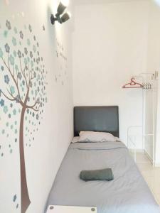 ein Schlafzimmer mit einem Bett mit einem Baum an der Wand in der Unterkunft Comfy Home Near to SPICE and USM in Bayan Lepas