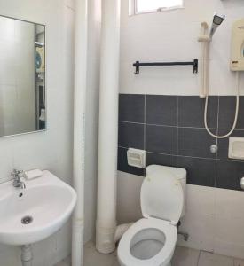 a bathroom with a white toilet and a sink at Comfy Home Near to SPICE and USM in Bayan Lepas
