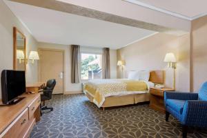 um quarto de hotel com uma cama e uma televisão em Days Inn by Wyndham Fairmont em Fairmont