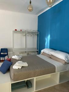 - une chambre avec un grand lit et un mur bleu dans l'établissement Amarcord, à Pouzzoles